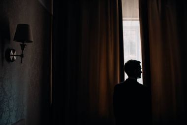 Otel penceresinden bakarak yakışıklı damat