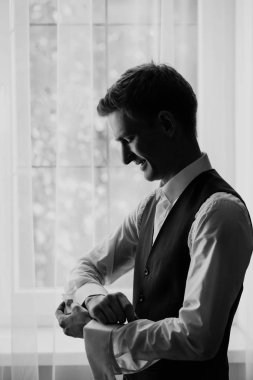 şık damat portre gecenin düğün için hazırlanıyor süre pencerenin.