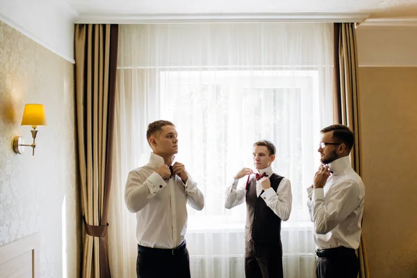 Three handsome male friends meet and speeking each other. Groomsman or best man greeting groom at wedding day.