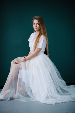 Güzel genç kadın ile studio poz beyaz elbiseli makyaj