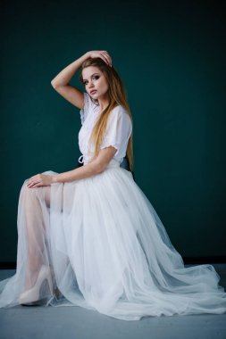 Güzel genç kadın ile studio poz beyaz elbiseli makyaj