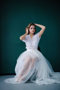Güzel genç kadın ile studio poz beyaz elbiseli makyaj