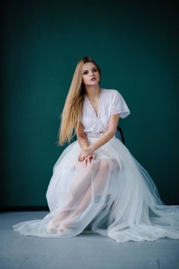 Güzel genç kadın ile studio poz beyaz elbiseli makyaj