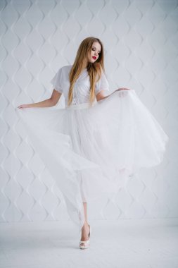 Güzel genç kadın ile studio poz beyaz elbiseli makyaj