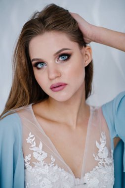 Güzel genç kadın ile studio poz mavi elbiseli makyaj