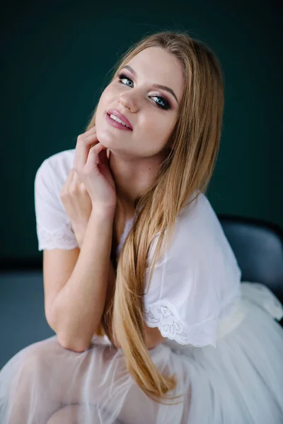 漂亮的年轻女子化妆在工作室的白色礼服 — 图库照片