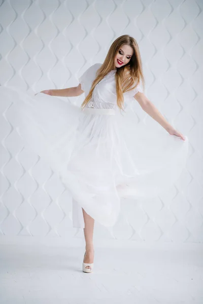 漂亮的年轻女子化妆在工作室的白色礼服 — 图库照片