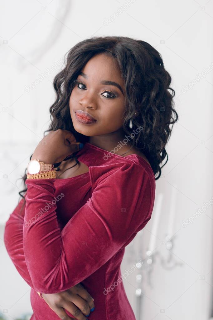 Beautiful young  African American woman in red dress posing in studio