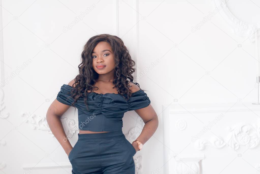 Beautiful young  African American woman in jumpsuit posing in studio