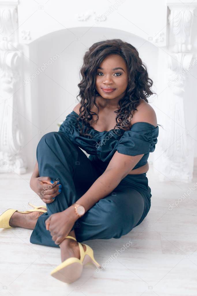 Beautiful young  African American woman in jumpsuit posing in studio