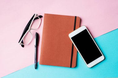 Ofis Masası boş smartphone, not defteri ve diğer malzemeleri ile Üstten Görünüm