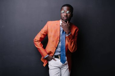 Kendine güvenen genç Afrika adam turuncu ceket poz 