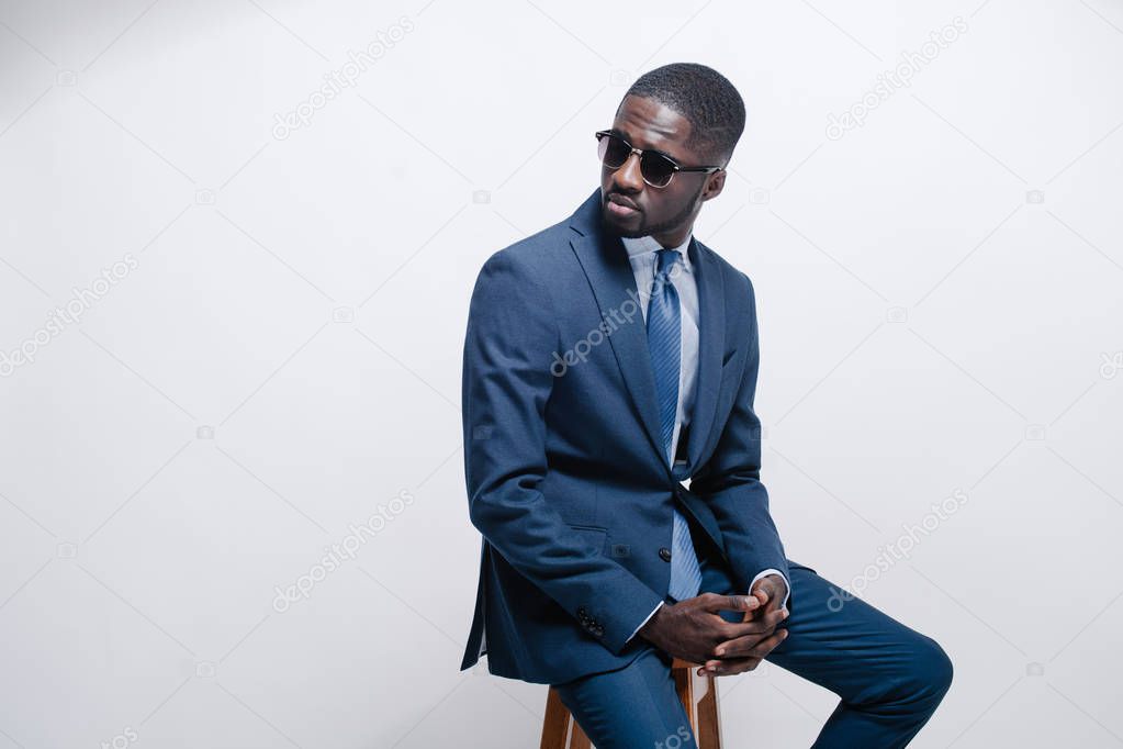 Confident young African man in a stylish suit posing in studio