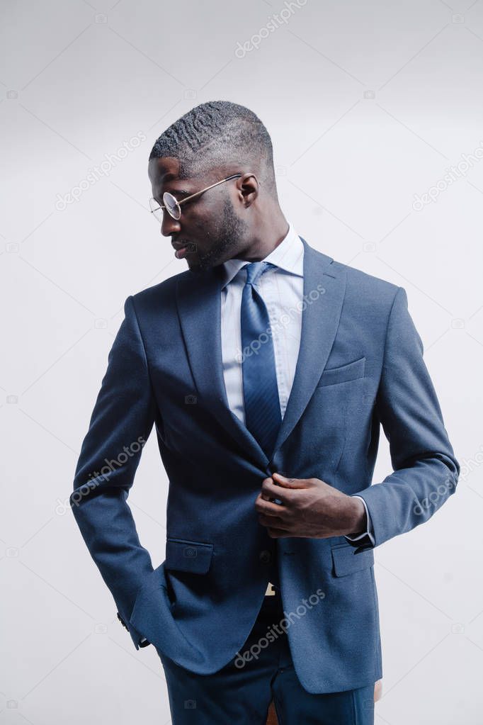 Confident young African man in a stylish suit posing in studio
