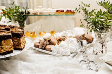 Çikolata paketiyle macarons, pasta kek, cheesecakes açılır. Bir iki renkli kurabiye katmanı servis tepsi.