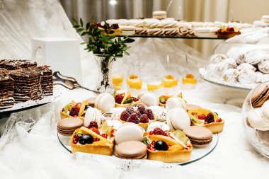 Çikolata paketiyle macarons, pasta kek, cheesecakes açılır. Bir iki renkli kurabiye katmanı servis tepsi.