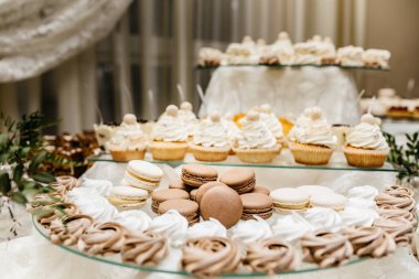 Çikolata paketiyle macarons, pasta kek, cheesecakes açılır. Bir iki renkli kurabiye katmanı servis tepsi.