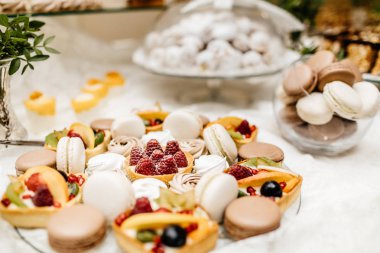 Çikolata paketiyle macarons, pasta kek, cheesecakes açılır. Bir iki renkli kurabiye katmanı servis tepsi.