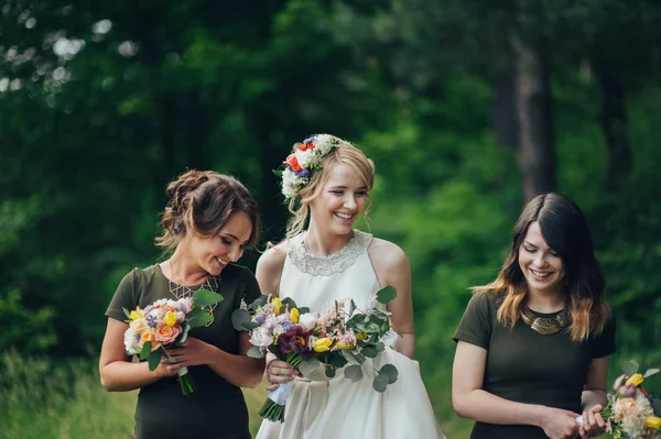 Positive moment of the bride with friends before wedding at forest