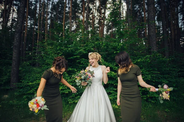 Positive moment of the bride with friends before wedding at forest