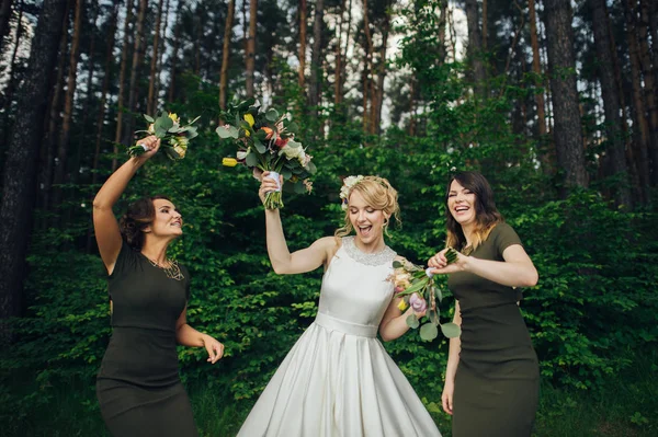 Positive moment of the bride with friends before wedding at forest