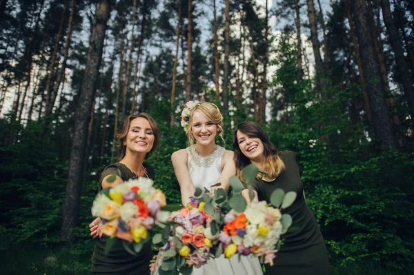 Positive moment of the bride with friends before wedding at forest