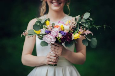 Ellerinde çiçeklerle güzel mutlu gelin