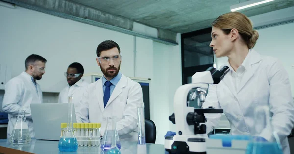 Eine Kaukasische Wissenschaftlerin Weißen Gewand Schaut Ins Mikroskop Während Sie — Stockfoto