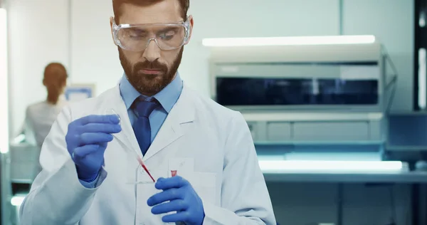 Biały Młody Człowiek Naukowiec Laboratoryjny Okularach Robiący Badania Krwi Rurką — Zdjęcie stockowe