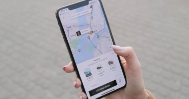 New York - 20-2020 arası, akıllı telefonu kadınların elinde kapatın. Uber uygulamasında telefon kullanan ve araba sipariş eden bir kadın. UberX uygulamasından taksi çağıran bir kız. Büyük şehirde ulaşım aranıyor.