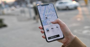 New York - 20-2020 arası, beyaz kadın ellerindeki akıllı telefonu kapat. Uber uygulamasında telefon kullanan ve araba sipariş eden bir kadın. UberX uygulamasından taksi çağıran bir kız..