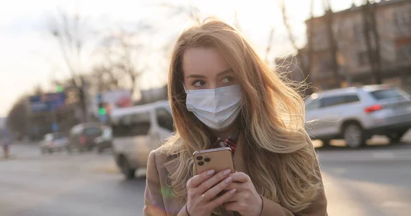 Mujer Joven Caucásica Mensaje Texto Máscara Médica Tocando Teléfono Móvil —  Fotos de Stock