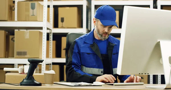 Retrato Entregador Uniforme Boné Sentado Mesa Loja Dos Correios Trabalhando — Fotografia de Stock