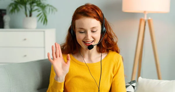 Retrato de bela menina ruiva alegre com fones de ouvido usando laptop. Mulher feliz tem chamada de vídeo . — Fotografia de Stock