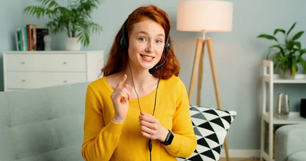 Portret pięknej rudej dziewczyny z słuchawkami mają połączenie wideo. — Zdjęcie stockowe