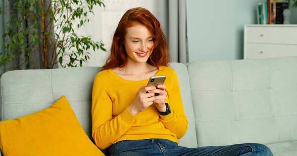 Красивая девушка покупает на смартфоне и платит кредитной картой, остаться дома
.