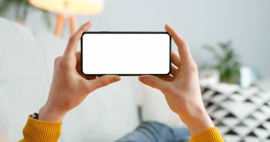 Yatay siyah akıllı telefonu kapat. Kadın ellerinde boş ekran var. Metnin için boş kopya alanı olan cep telefonu