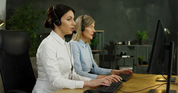 Porträt der schönen kaukasischen jungen Frau mit Headset, die am Computer im Callcenter arbeitet. — Stockfoto
