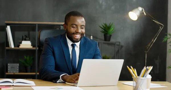 Afroamerikansk affärsman sitter vid bordet och har videochatt på bärbar dator. — Stockfoto