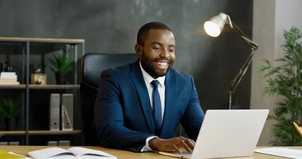 Afroamerikansk affärsman sitter vid bordet och har videochatt på bärbar dator. — Stockfoto