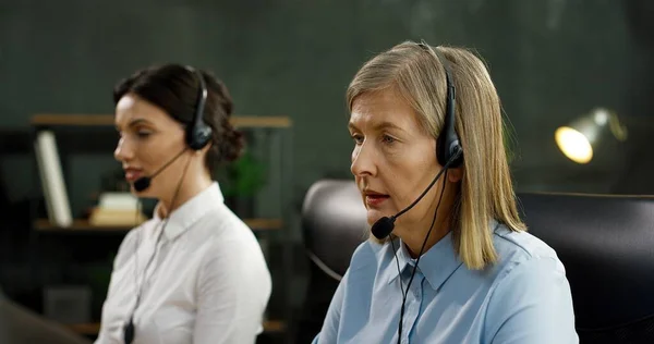 Großaufnahme einer kaukasischen Seniorin im Headset, die im Büro eines Callcenters arbeitet. Dienstleistungskonzept für Kunden. — Stockfoto