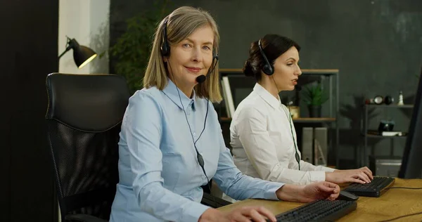 在呼叫中心办公室工作的白种人老年妇女的近照。为客户服务的概念. — 图库照片