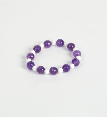 Beyaz bir arka plan üzerinde doğal taşlarından yapılmış bilezik