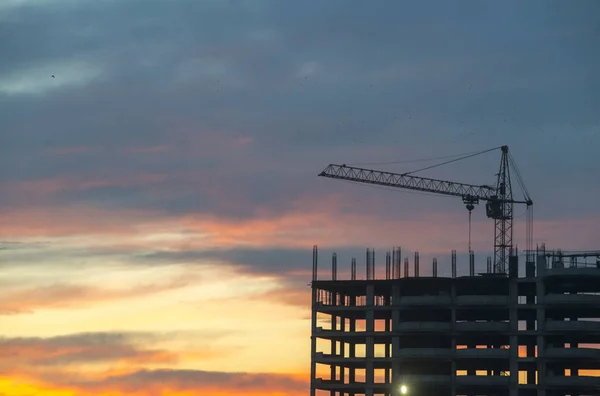 Ipari építőipari daruk és épület sziluettek a nap felett — Stock Fotó