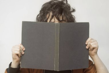 Bir çocuk onun elinde bir kitapla