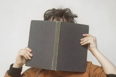 Bir çocuk onun elinde bir kitapla