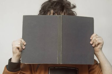 Bir çocuk onun elinde bir kitapla