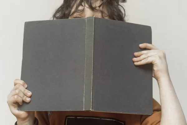 Băiețelul își ascunde fața în spatele unei cărți — Fotografie de stoc gratuită