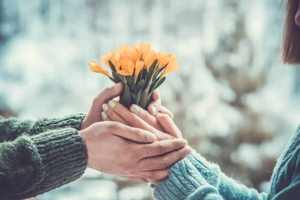 Jovem casal amoroso de mãos dadas um ao outro com buquê de yel — Fotografia de Stock