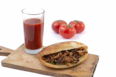 Pide ekmeğinde shawarma, domates ve domates suyu beyaz bir arka planda.